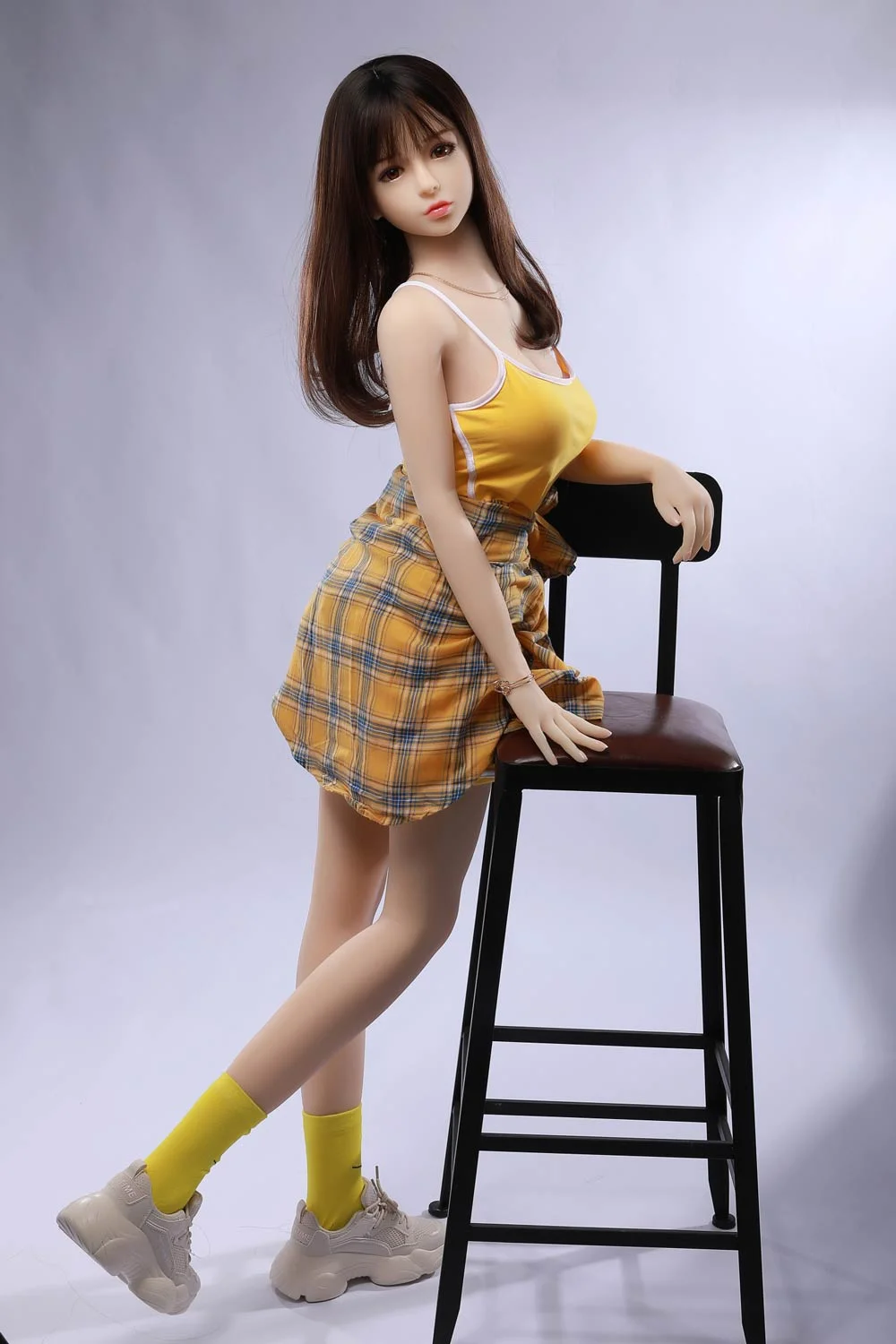 Mini sex doll with hands on the stool