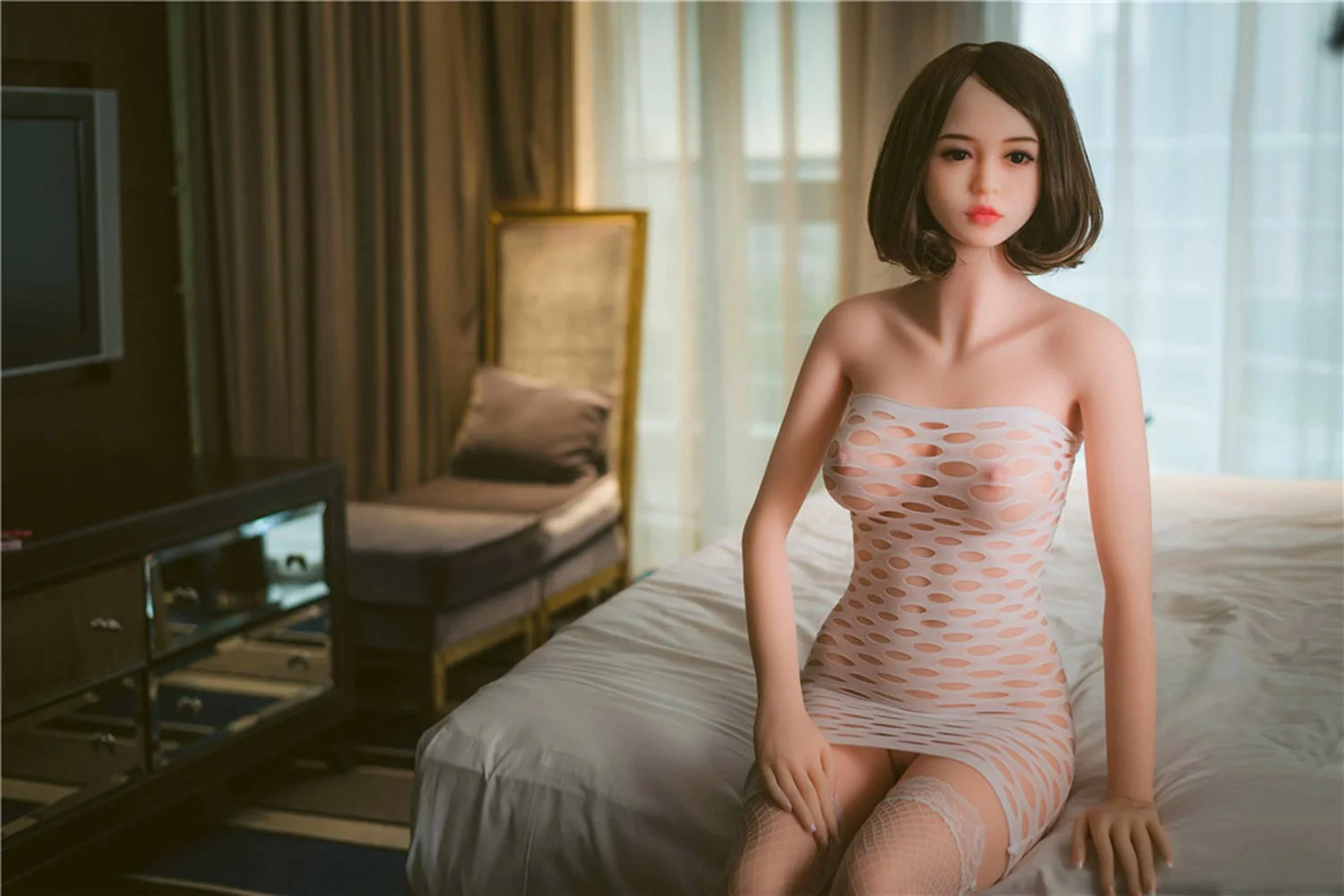 Sex doll sitting on the bed with hands on thighs