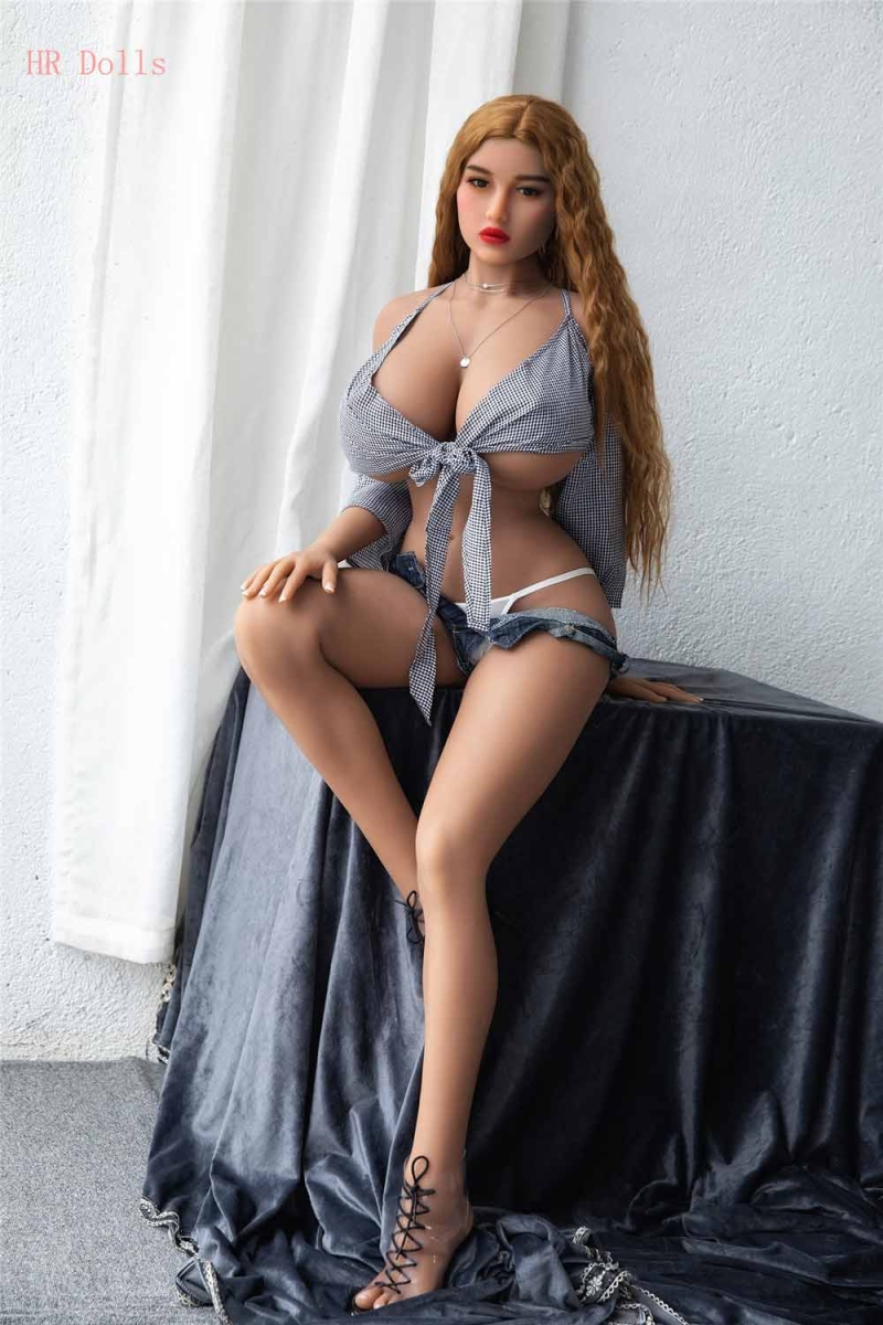 Big breasted sex doll sitting on the table