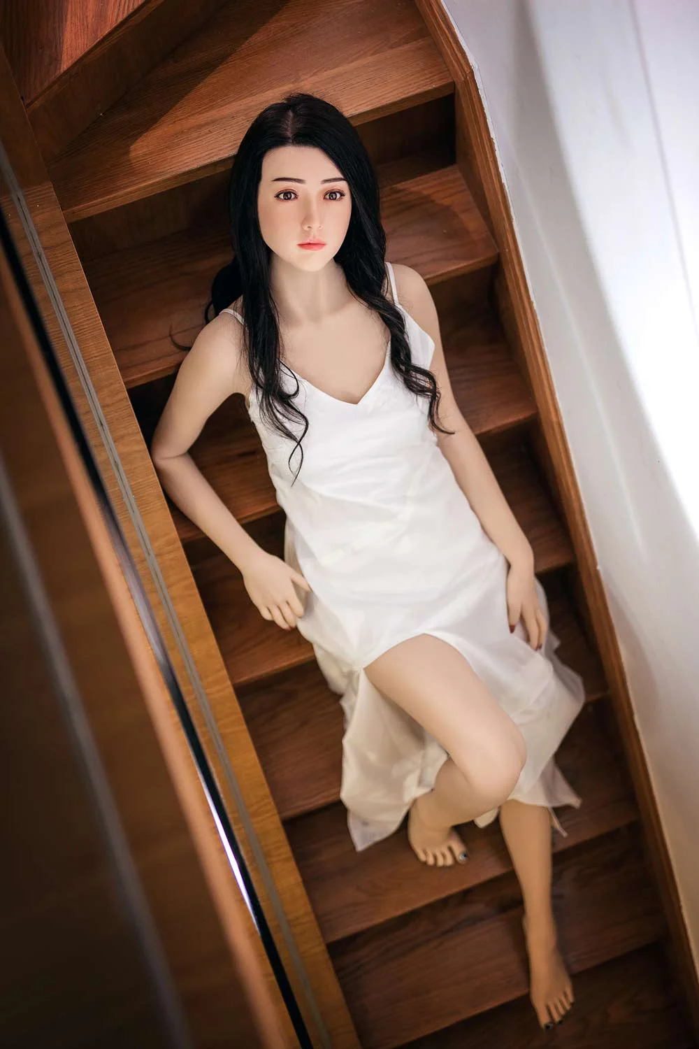 Silicone sex doll lying on the stairs