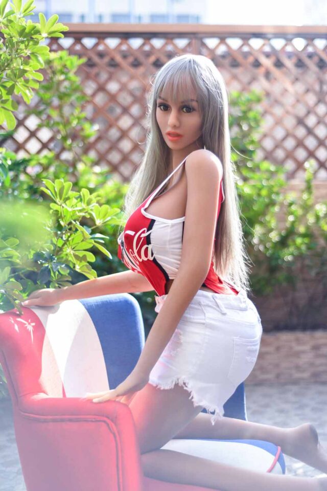 Big breasted sex doll kneeling on a chair