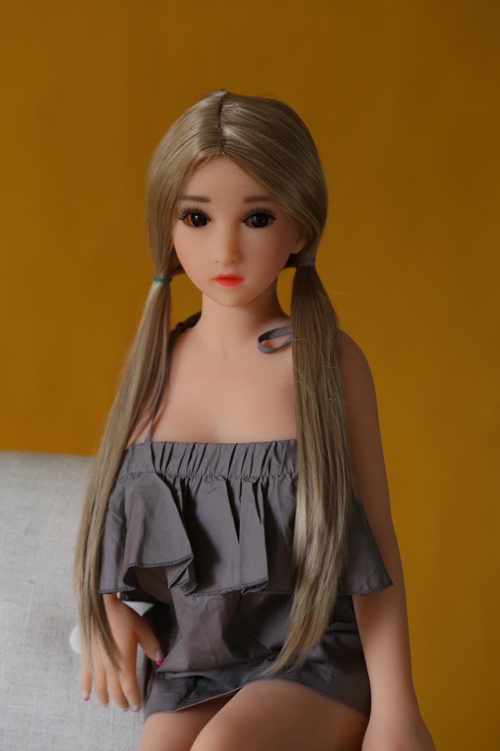 Blond-haired mini sex doll in a suspender skirt