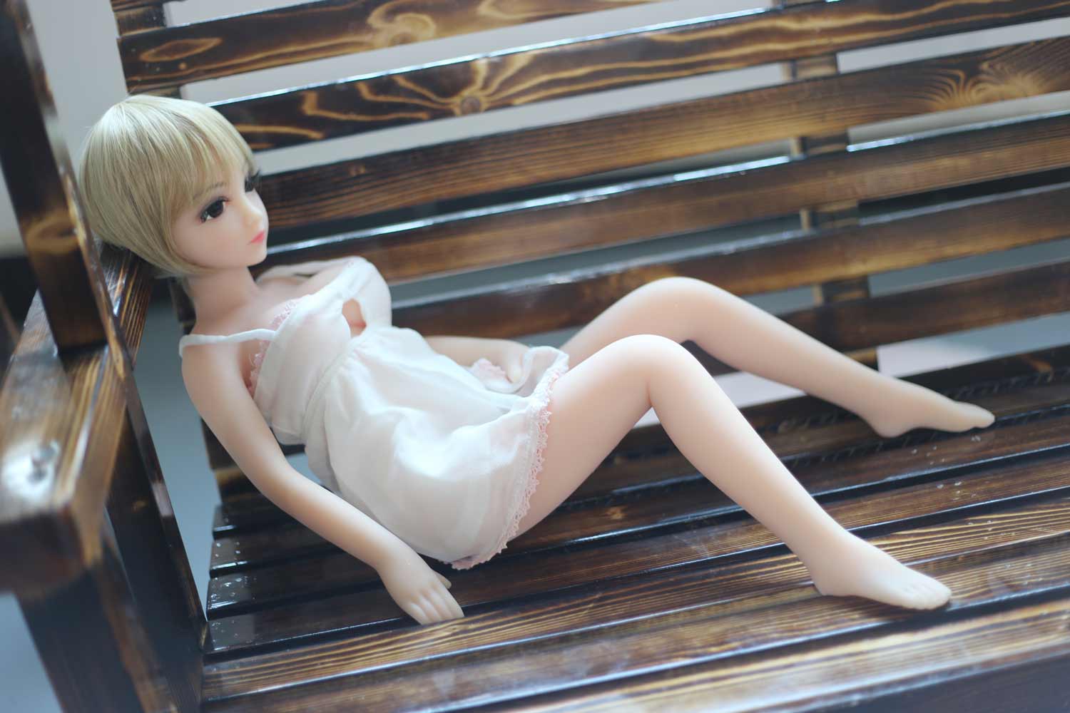 Mini sex doll lying in a chair