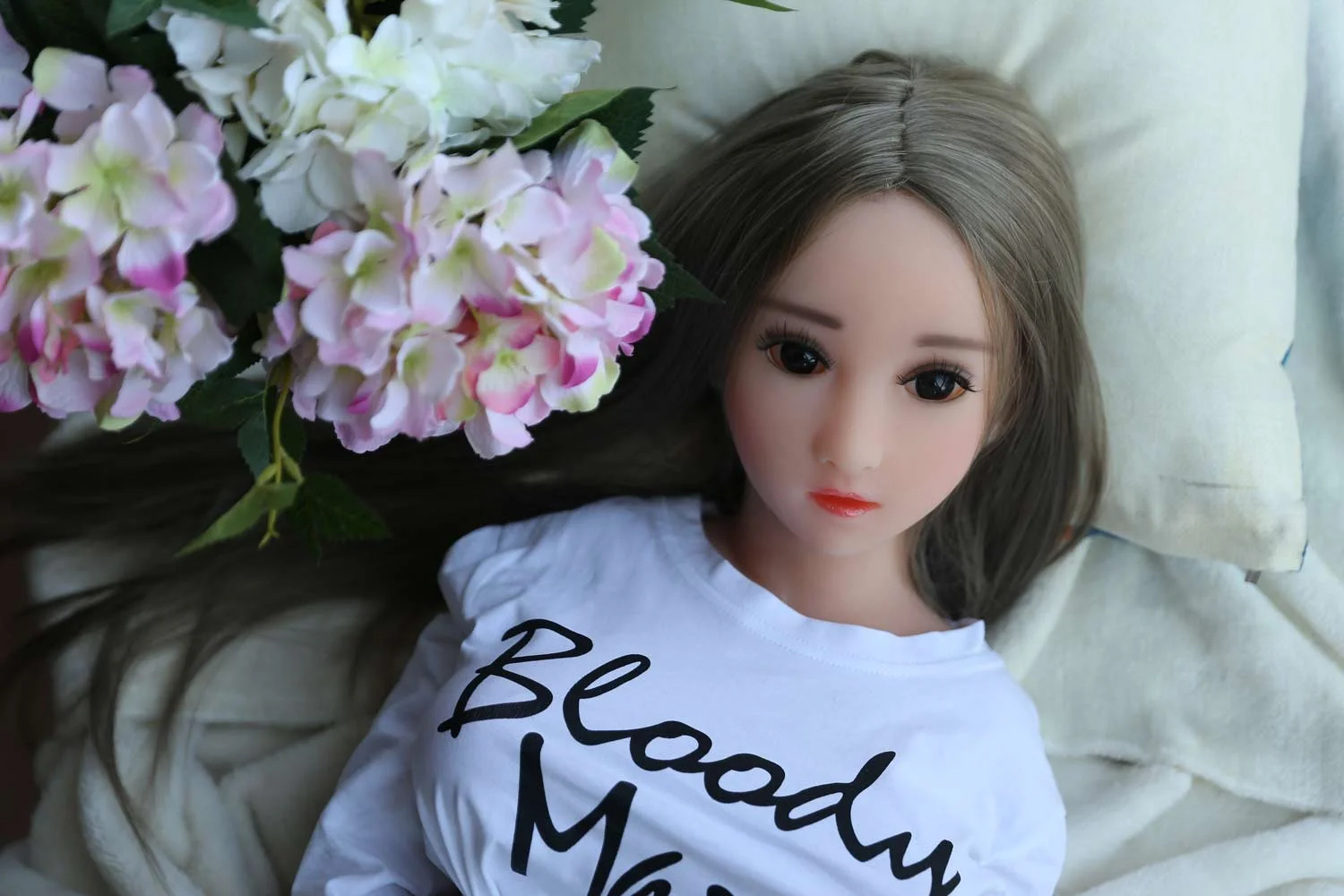 Mini sex doll lying on the bed