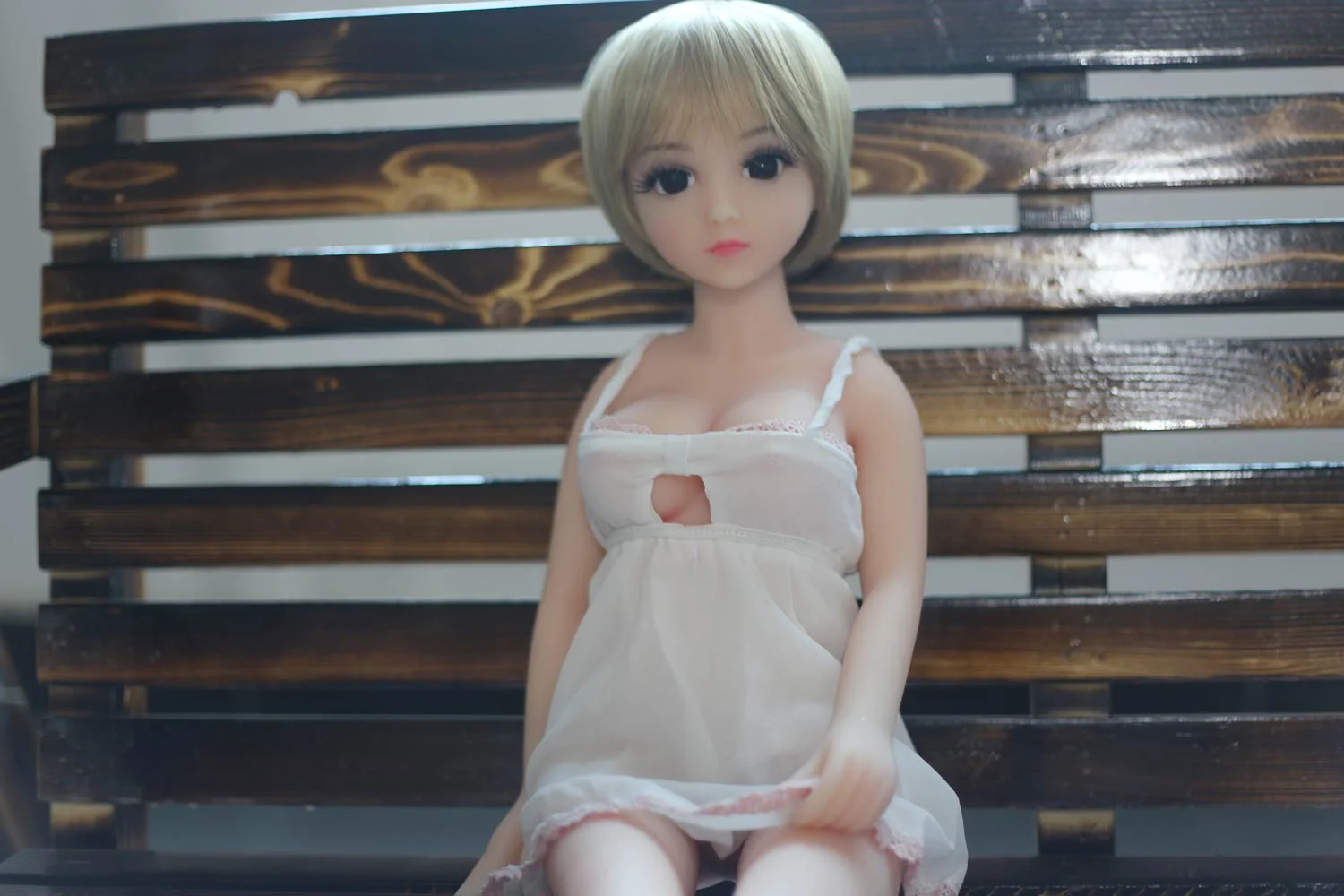 Mini sex doll sitting in a chair
