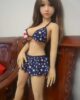 Mini sex doll standing on a chair