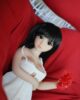 Mini sex doll with black long hair and red flower in hand
