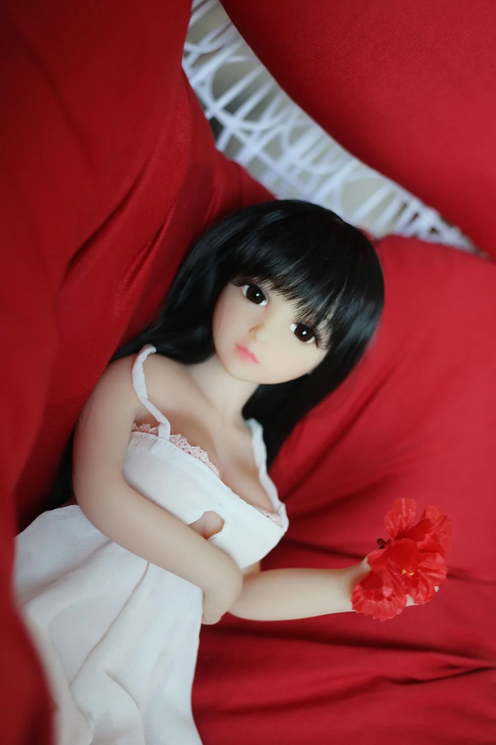 Mini sex doll with black long hair and red flower in hand