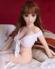 Mini sex doll with hands on the bed