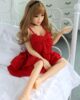 Mini sex doll with hands on the bed railing