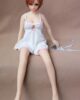Mini sex doll with short brown hair sitting on the sofa