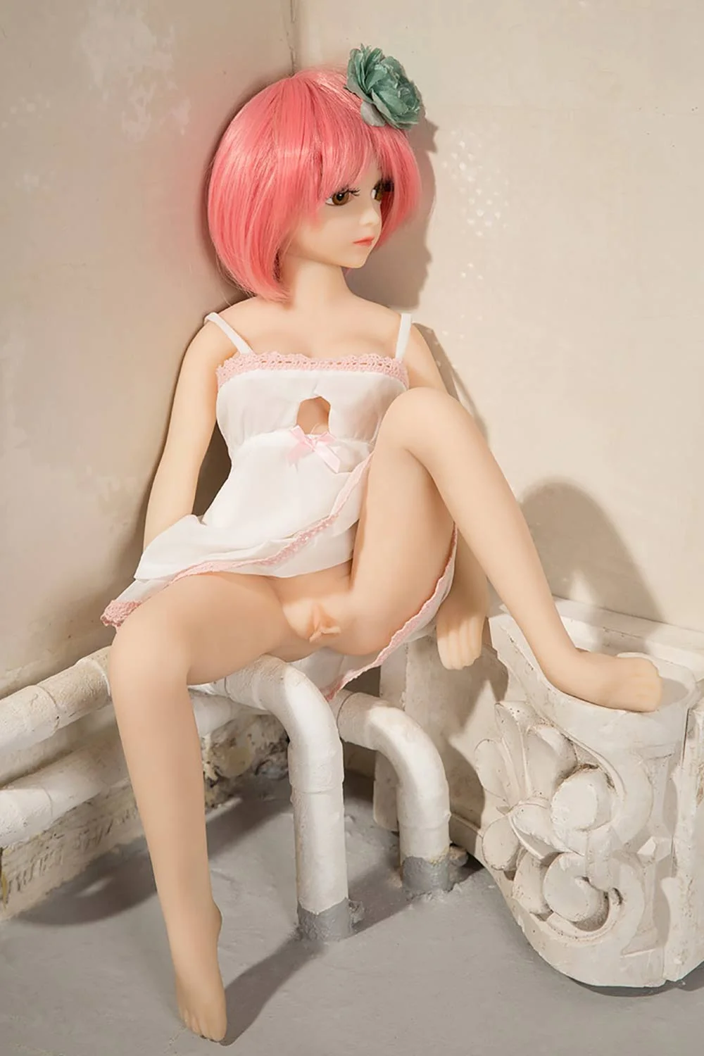 Mini sex doll with short pink hair showing vagina