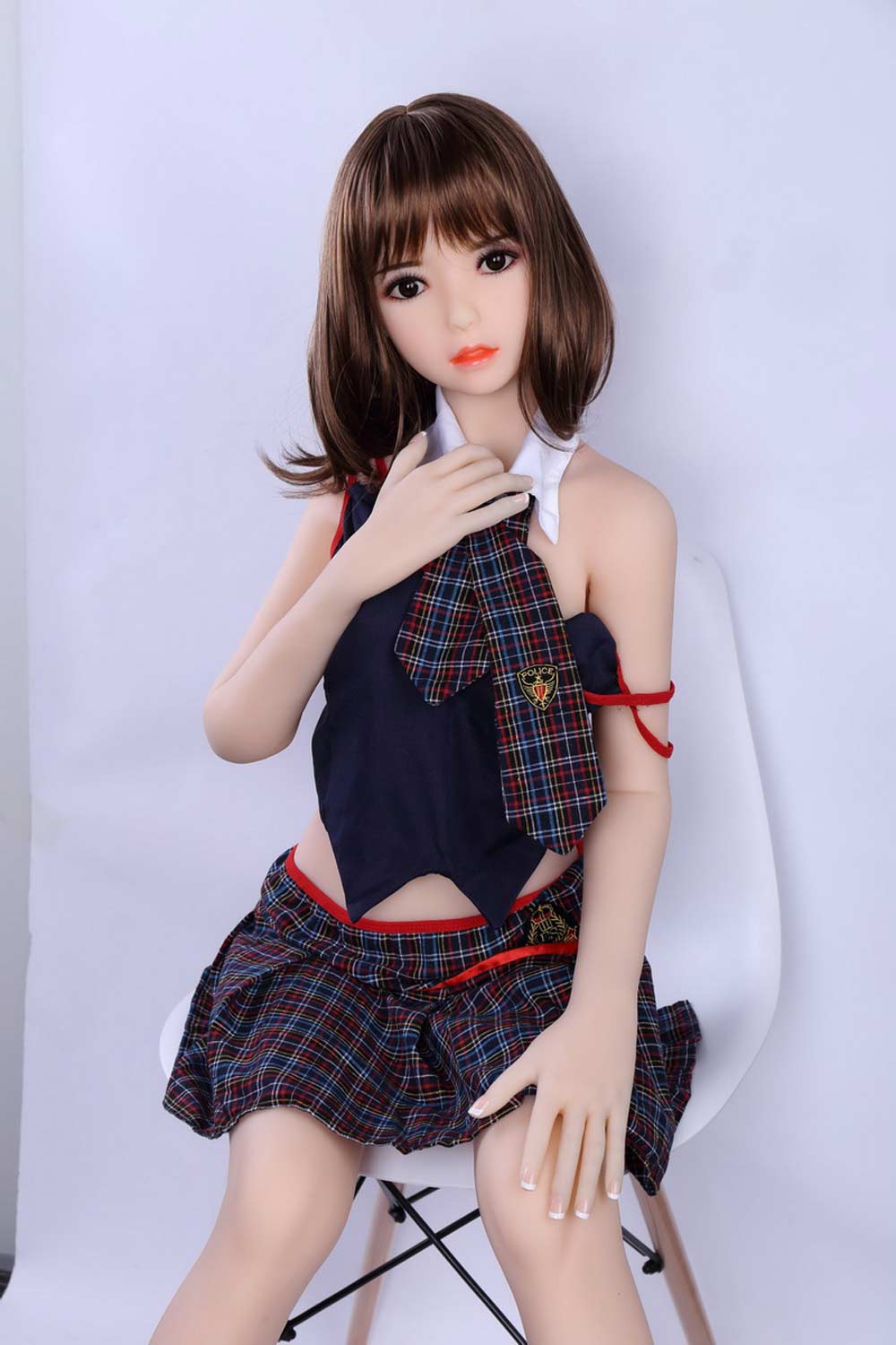 A mini sex doll in a plaid pleated skirt