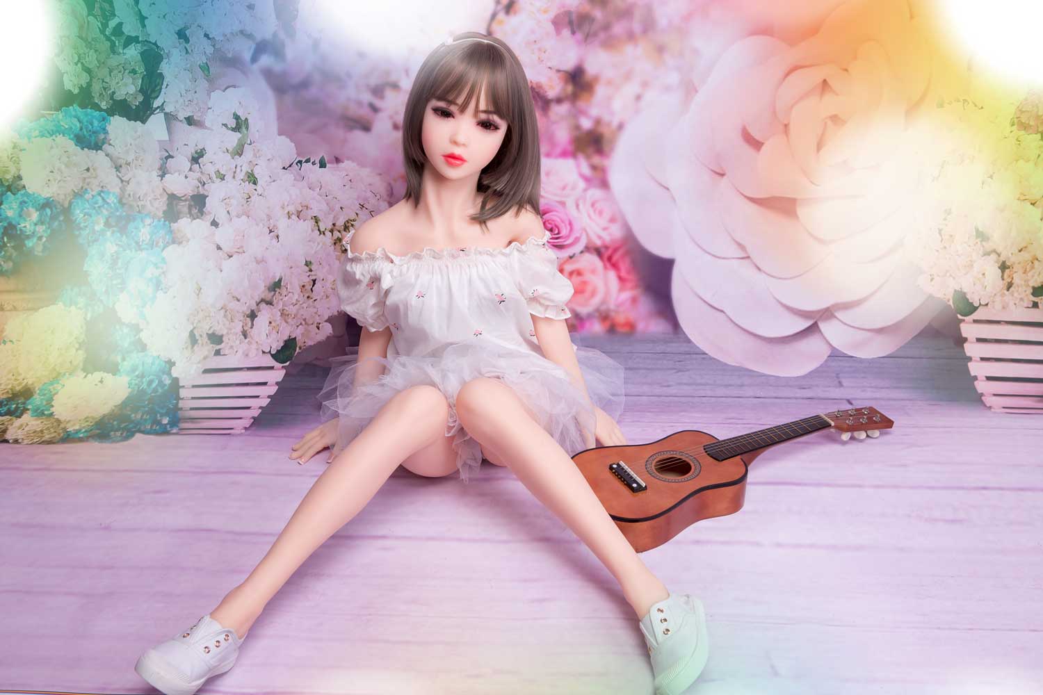 A mini sex doll sitting on the ground with legs apart