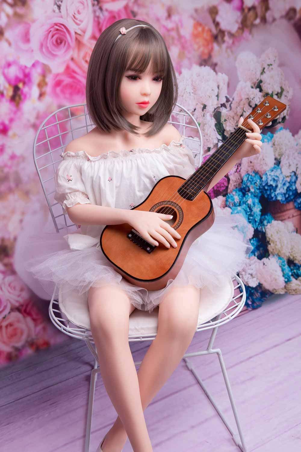 Mini sex doll sitting on a chair