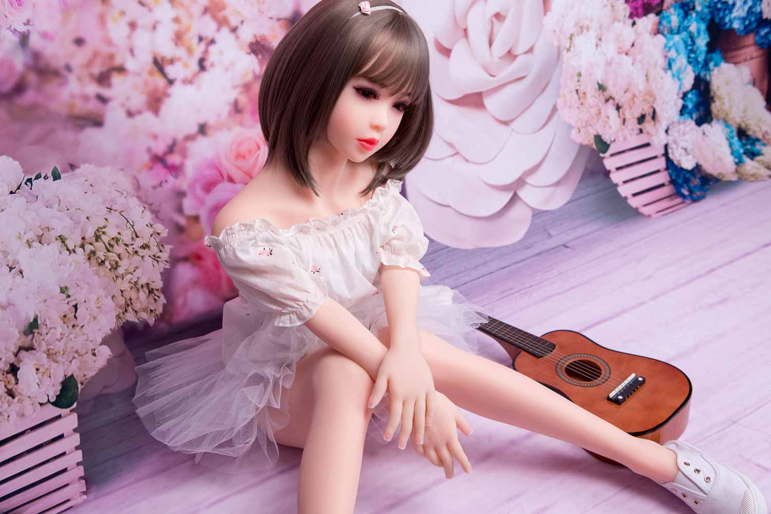 Mini sex doll with guitar next to it