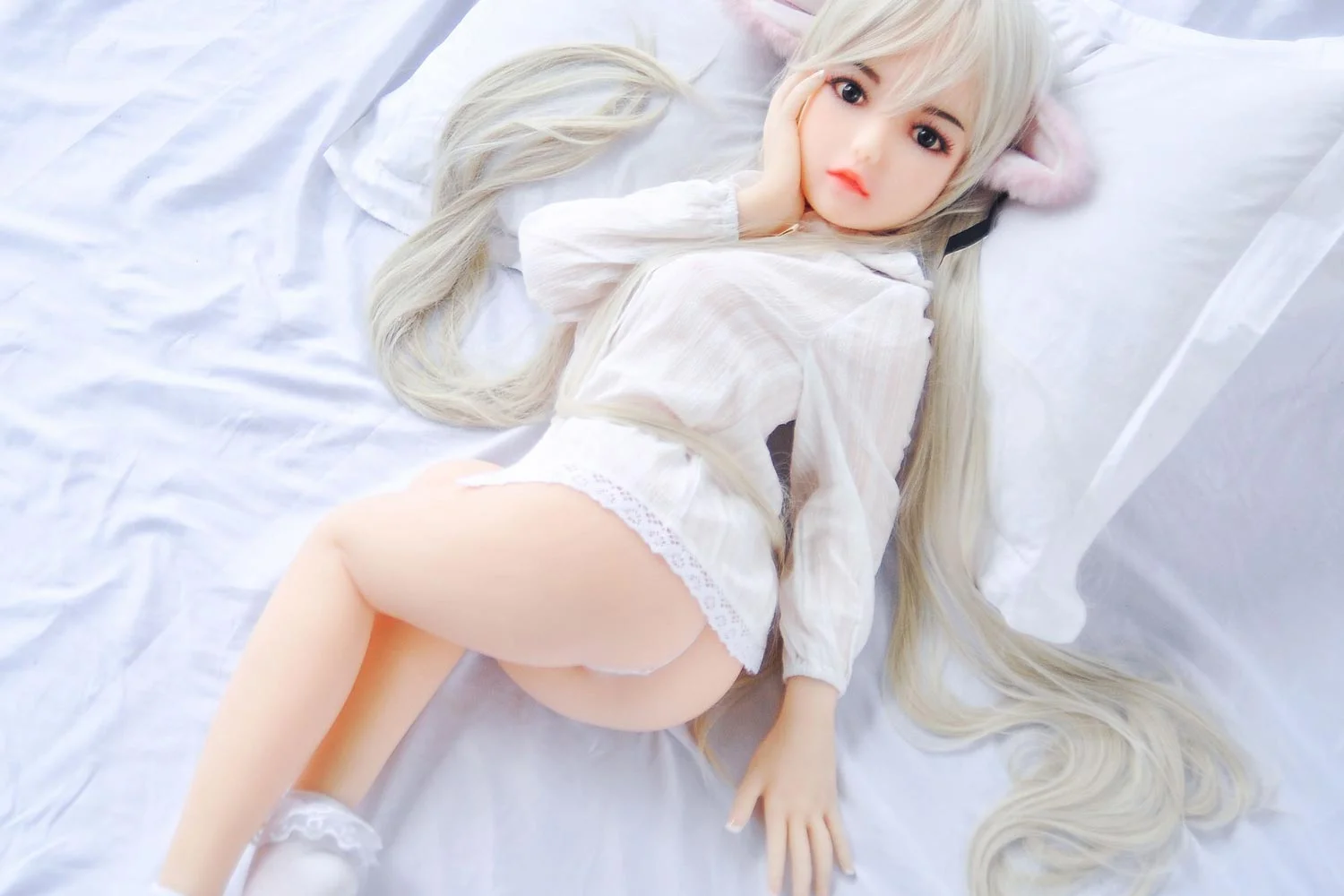 Mini sex doll with hands on the bed