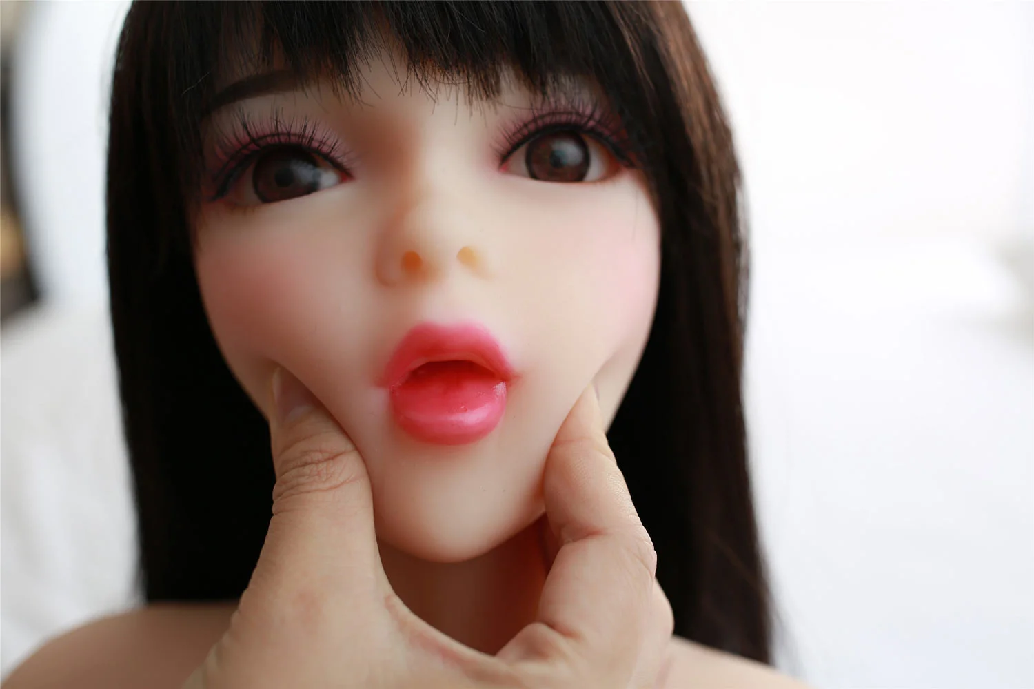 Mini sex doll with someone holding his chin