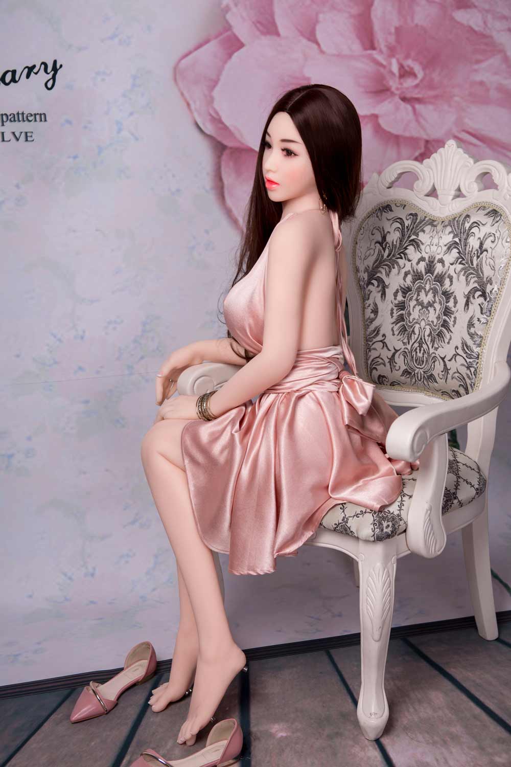 Sex doll with hands on chair armrests