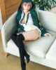 Anime sex doll sitting on the sofa with hands on thighs