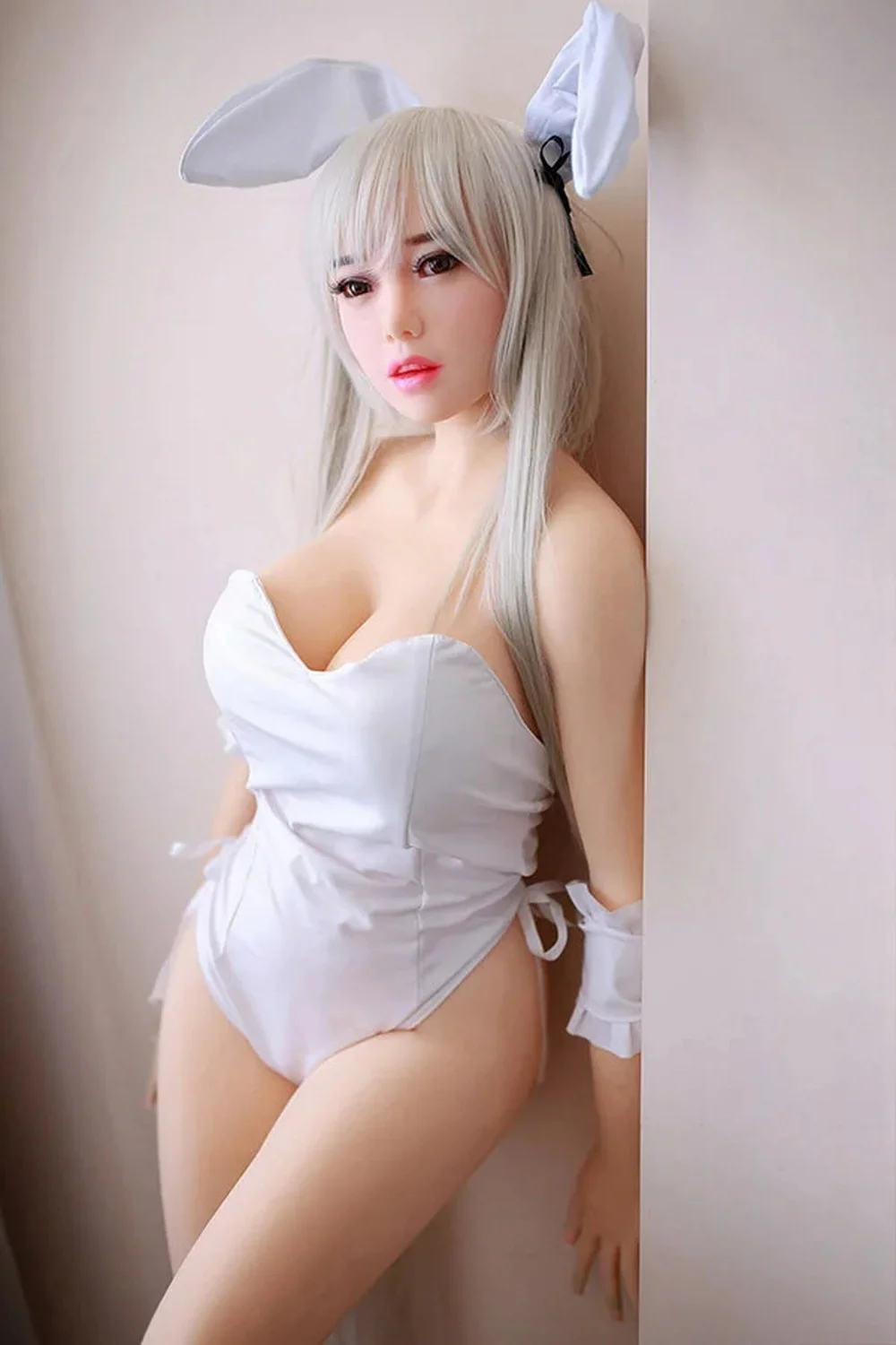 Anime sex doll wearing white bunny clothes leaning against the wall