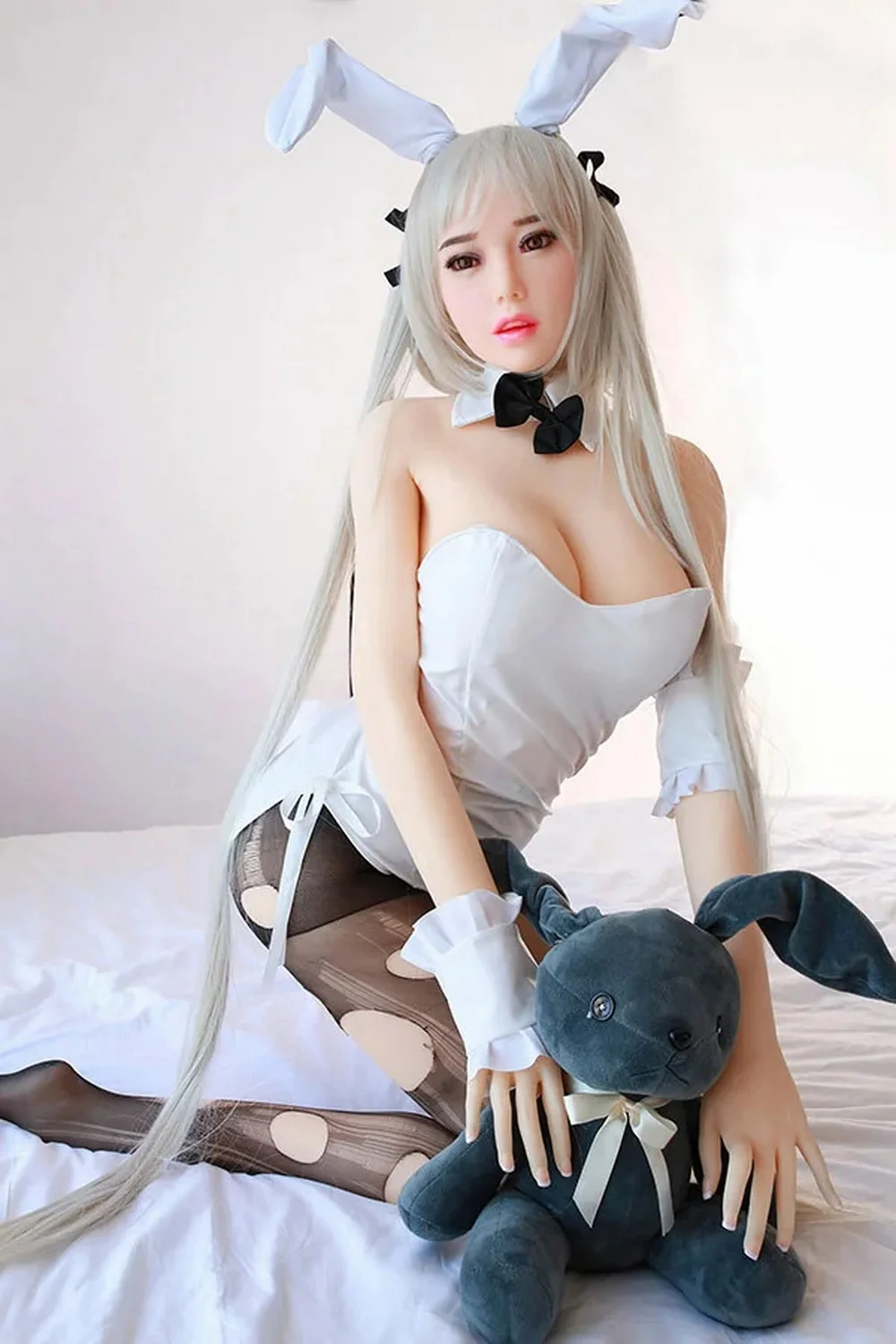 Anime sex doll with legs kneeling on the ground holding a doll in hand