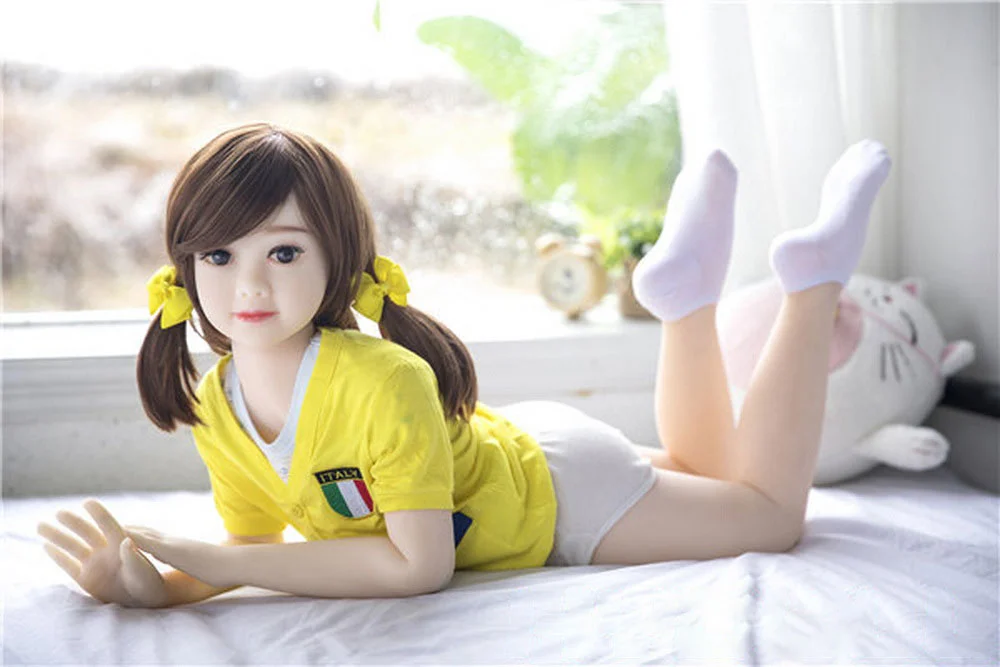 A mini sex doll lying on the ground with legs raised
