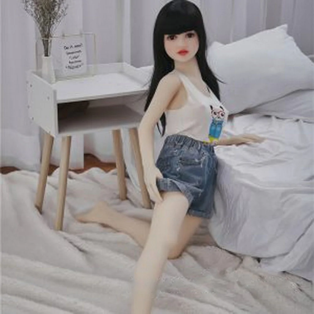 Kneeling on the ground and pulling up the trousers of the mini sex doll