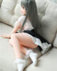 Mini sex doll with legs bent and hands on the sofa