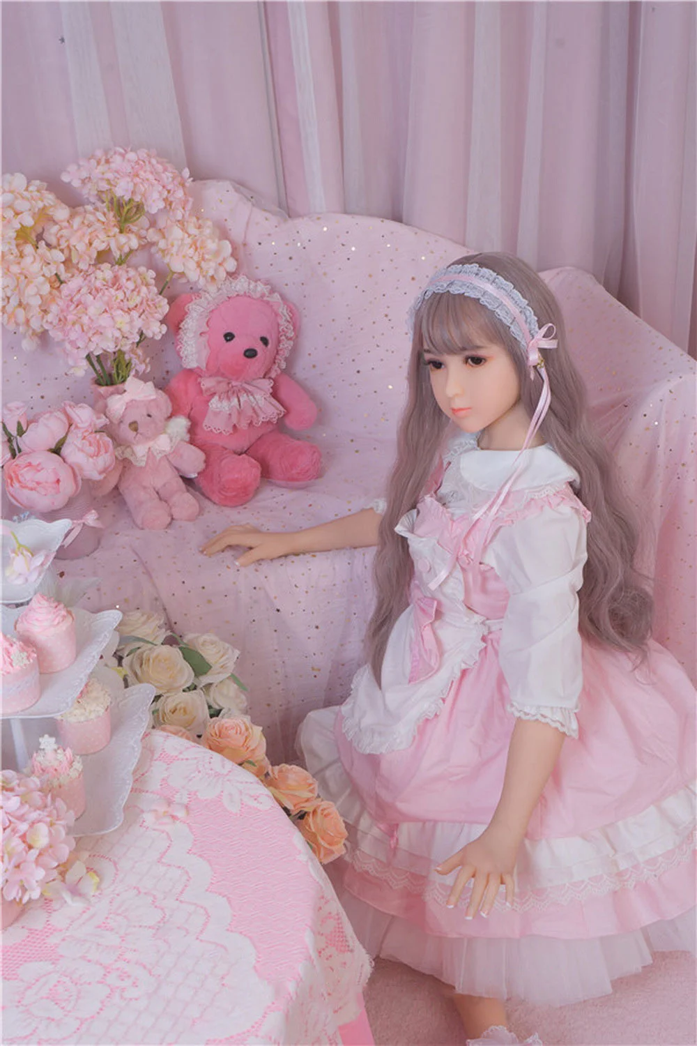 Sex doll kneeling on the floor with hands on the sofa