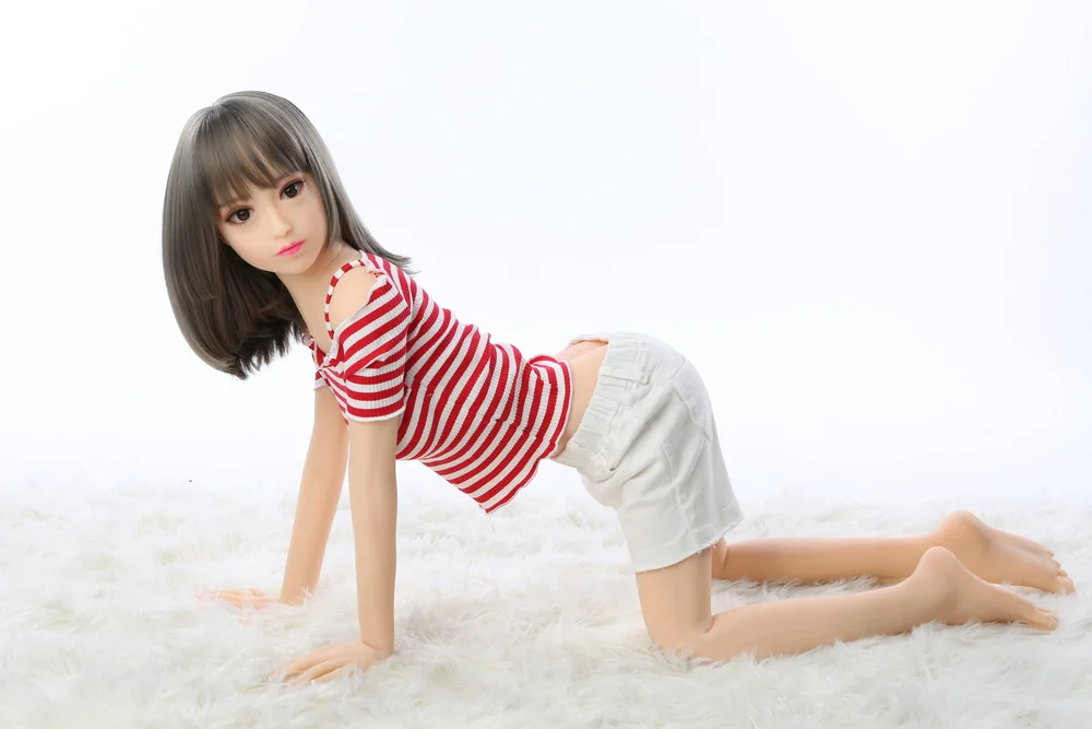 Sex doll kneeling on the ground with hands on top