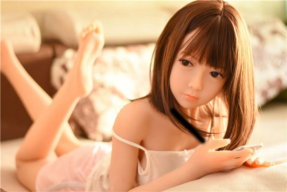 Sex doll lying on the bed with legs raised