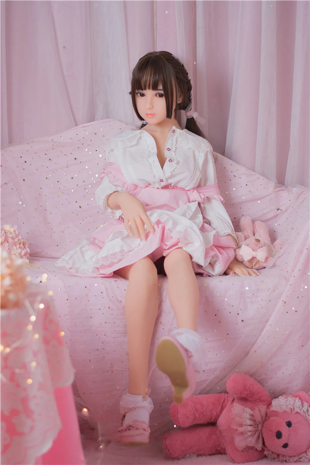 Sex doll sitting on the sofa with hands on top