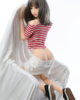 Sex doll with legs kneeling on the sofa and pulling down pants